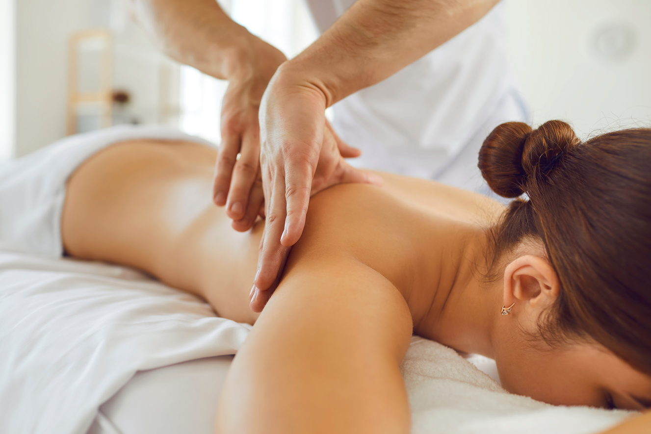 Female Lying on Massage Table Getting Delicate Body Massage in Wellness Center or Spa Salon